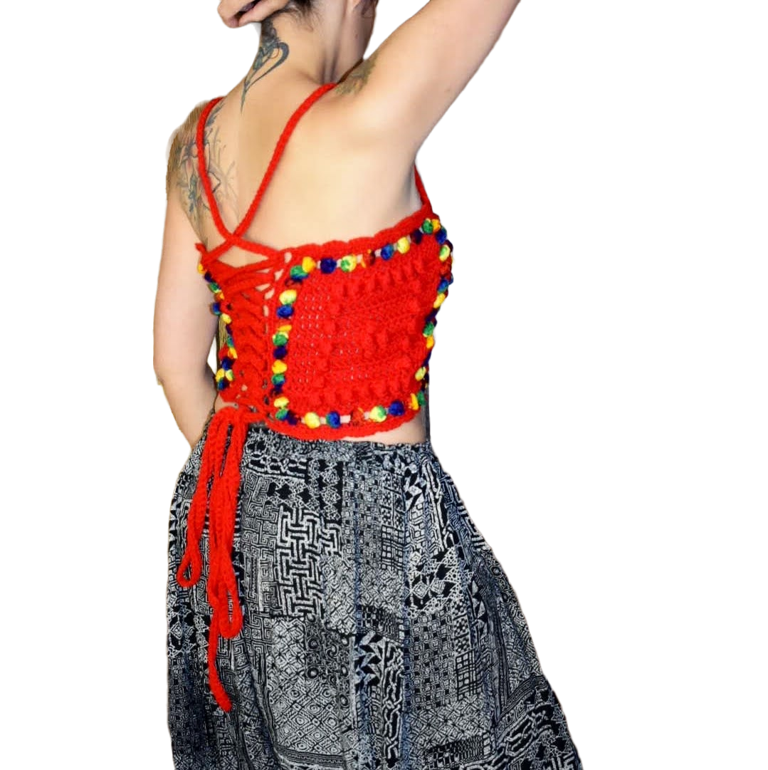 Side/rear view of woman wearing granny square crochet top with lace up back.