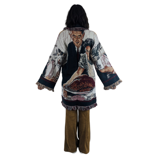 Back view of woman wearing a tapestry blanket coat featuring Norman Rockwell's Thankgiving Dinner Picture.