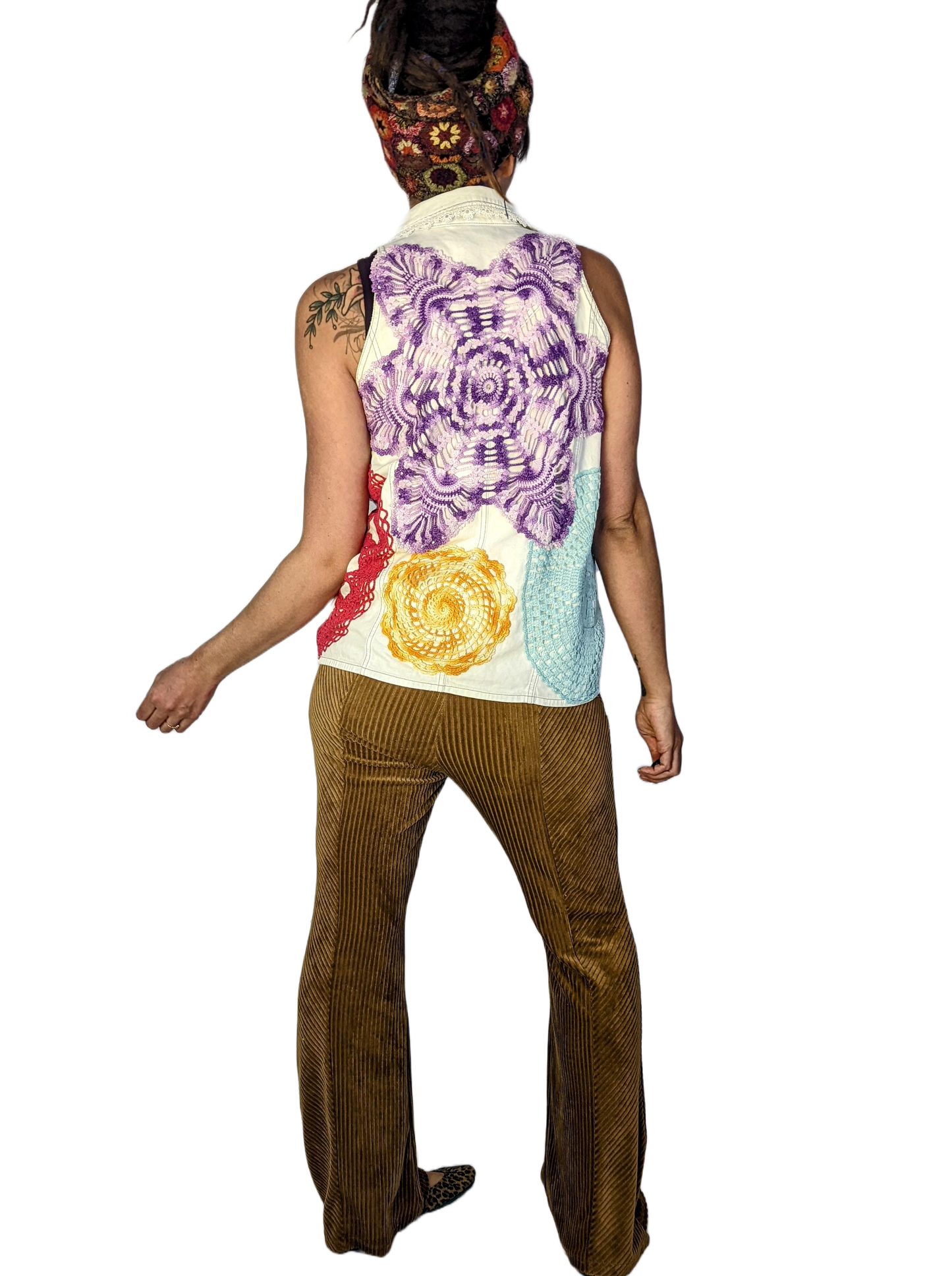 Woman is wearing cottagecore style white vest with repurposed doilies on it.