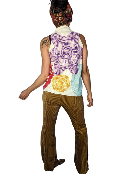 Woman is wearing cottagecore style white vest with repurposed doilies on it.